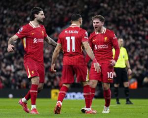 Alexis Mac Allister (right) celebrates with Dominic Szoboszlai and Mo Salah during Liverpool's...