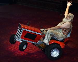 Alain Carabinier, of Quebec, does a wheelie on a miniature tractor in the foyer of the Regent...