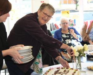 Teacher aide Beth Hewlett divvies up her celebratory cake as West Gore School celebrates her 25th...