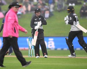 Georgia Plimmer and Suzie Bates of New Zealand depart the field for a rain delay. Photo: Getty...