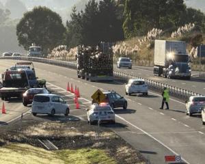 Police direct traffic at the Fairfield on-ramp following a crash yesterday morning. Photo: Craig...