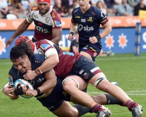 The Highlanders’ Tanielu Tele’a scores a try while tackled by Harry Wilson of the Queensland Reds...