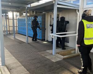 Members of the Armed Offenders squad rush into Cromwell College during a drill last week. PHOTO:...