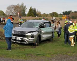 A tour group watches from their white van as emergency services speak with members of the group...