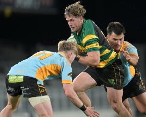 Green Island wing Michael Manson is sandwiched by University defenders Finlay Hagen (left) and...