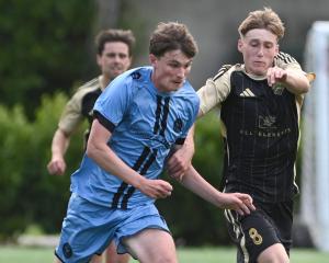 Dunedin City Royals player Jack Julian (left) and Wanaka’s Phoenix Coursey battle for the ball...
