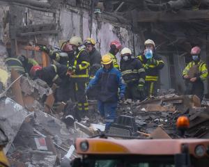 Rescue workers search for people under rubble of an apartment building in Svyatoshynskyi district...