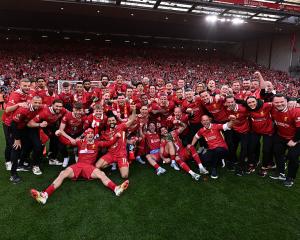 Liverpool players celebrating after being named champions of the Premier League at Anfield after...