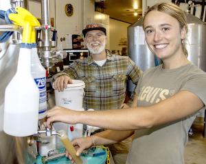 Poppy Pett and The Laboratory head brewer Mark Waller testing the temperature of Pett’s brew....