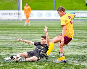 Christchurch United’s Charlie Beale slides to win the ball off Universities Isaac Topham. PHOTO:...