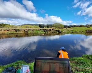 An Environment Southland environmental technical officer measures river flow with an acoustic...
