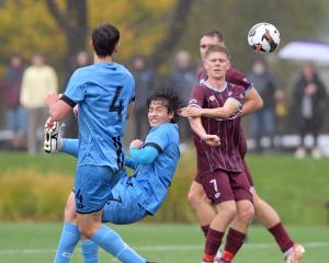 Dunedin City Royals attacker Em Watanabe (second right) has a crack at a bicycle shot on goal...