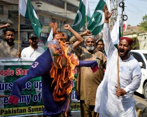 Demonstrators burn an effigy during an anti-India protest in Hyderabad following India's military...