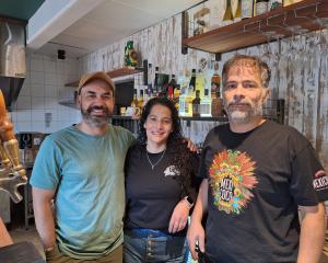 Behind the bar at Caribe on Fire are, from left, Santiago Bonhomme, Carolina Guajardo and Richard...