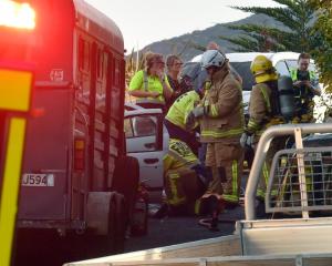 Fire fighters attend to patients from a car crash between a car and a ute towing a horse float on...
