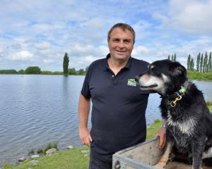 The late Chris Allen, with working dog Ace beside the irrigation lake he created on his farm near...