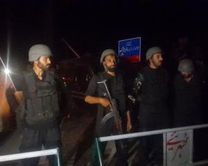 Pakistani soldiers take security measures around the city of Muzaffarabad, Pakistan as people...