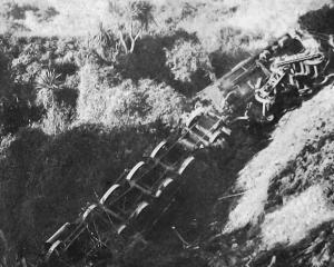 A derailed AB steam locomotive and its tender lie upside down in a gully at Kakahi near...