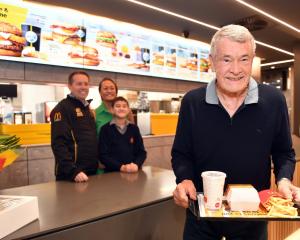 Ray Stonelake sen is served the first meal at the new Green Island McDonald’s by his son Justin,...