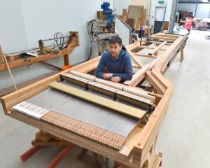 Dunedin piano builder Adrian Mann sits at one of two Alexander pianos he is building for a buyer...