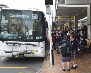 Secondary school students wait for the bus at the 151 Princes St stop in Dunedin yesterday. PHOTO...