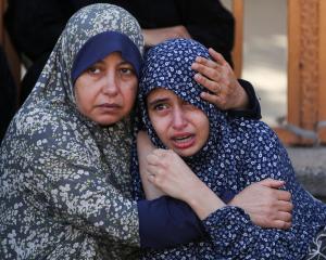 Palestinian women mourn after at least 24 people were killed by Israeli fire near an aid...