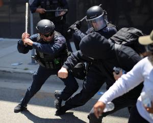Members of the Los Angeles Metro Police clash with demonstrators during a protest against federal...