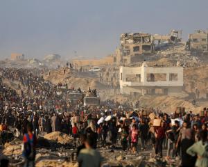 Thousands of Palestinians gather to receive aid supplies in Beit Lahia, in the northern Gaza...