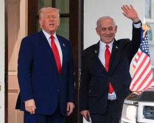 President Donald Trump speaks as Israeli Prime Minister Benjamin Netanyahu waves following a...