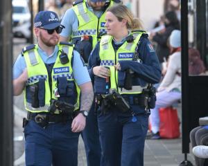 Police scan the bus hub in Great King St, Dunedin, on Friday, after reports of a man with a...