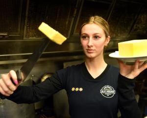 Speight’s Ale House Dunedin staff member Bella Mangos holds up a sliced pound of butter. PHOTO:...