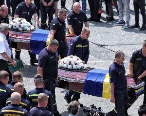 Comrades carry the coffins with the bodies of the fallen rescuers in Kyiv, Ukraine. Photo: Getty...