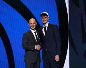 Cooper Flagg (right) shakes hands with NBA commissioner Adam Silver after being selected first...