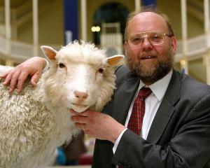 Dr Ian Wilmut, leader of the team that created Dolly the sheep, poses by her taxidermied body as...