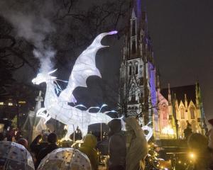 A glowing dragon exhales a smoke cloud over visitors eagerly waiting to be let into the Dunedin...