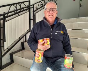 South Island Rotary district governor Dave McKissock is ready to collect cans of food for project...