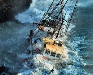 Fishing vessel Tamahine rocks in the waves at Taiaroa Head, at the tip of Otago Peninsula. It...