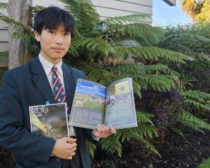 Mountainview High School international student Shou Saito shows off his published report on South...