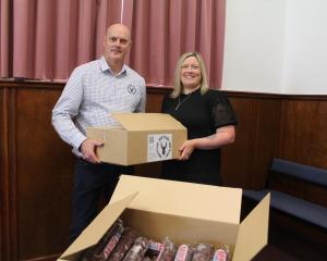 Deer to Care co-owner Stu O'Neill hands Gore &amp; Clutha Whānau Refuge manager Talia Marshall a...