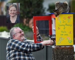 Halie McEachen’s father, Stu McEachen, pulls a book from the Lilliput library he built in memory...