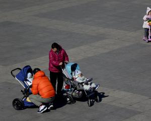 Beijing residents bring their babies to a local park. PHOTO: AP