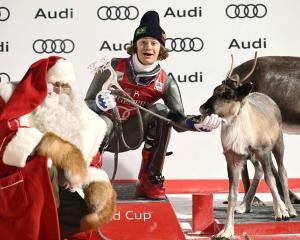 Brazilian skier Lucas Pinheiro Braathen feeds one of Santa Claus’ reindeer after winning the men...