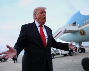 Donald Trump speaks to reporters on the tarmac after returning to Washington. Photo: Reuters 