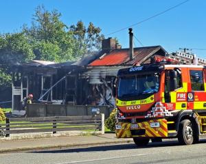Fire crews outside the house that was destroyed in Mataura this morning. Photo: Gerrit Doppenberg
