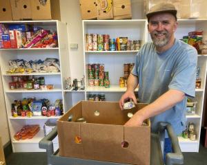 Presbyterian Support Otago Family Works Foodbank co-ordinator Adam Doesburg loads up a box of...