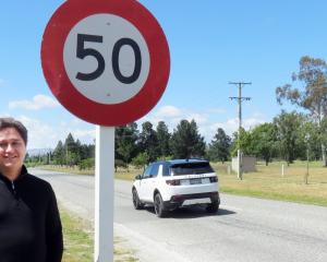 Vincent Community Board chairman Jayden Cromb poses with one of the new signs in Clyde replaced...