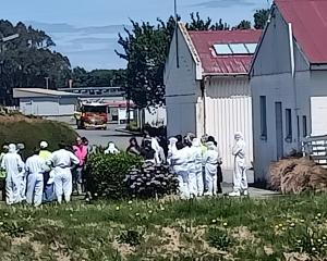 Evacuated workers congregate outside Quality Foods Southland in Invercargill. Photo: Toni...