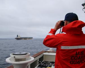 A US Coast Guard official keeps an eye on the Marinera. PHOTO: US EUROPEAN COMMAND via X and ...