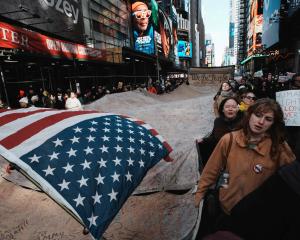 Demonstrators in New York City hold a giant sign during a "No Kings" protest against US President...