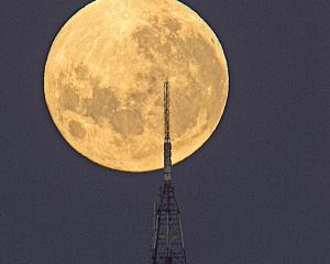 The moon looms huge and gold behind Kapukataumahaka Mt Cargill. PHOTO: IAN GRIFFIN